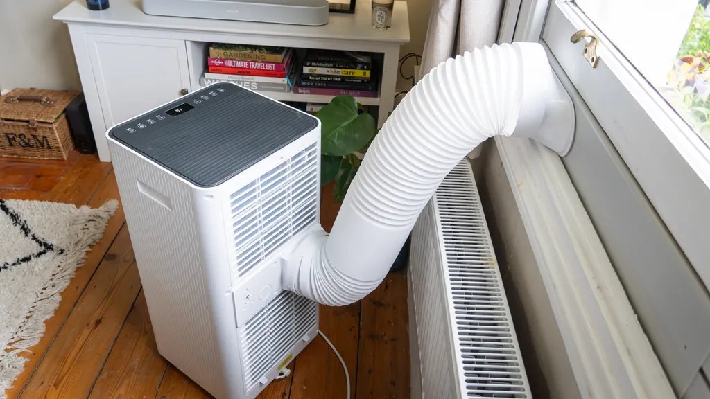 MeacoCool MC Series Pro 10000 use a wide ducting pipe to expel warm air out of an open window.